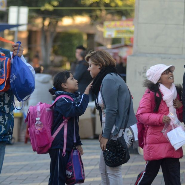 Mamá e hija se despiden, abrigadas, al ingresar a las clases